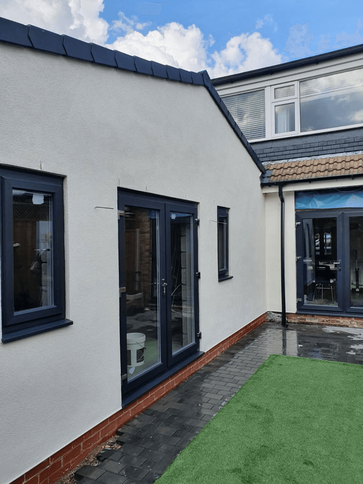 Light grey rendered extension with anthracite windows