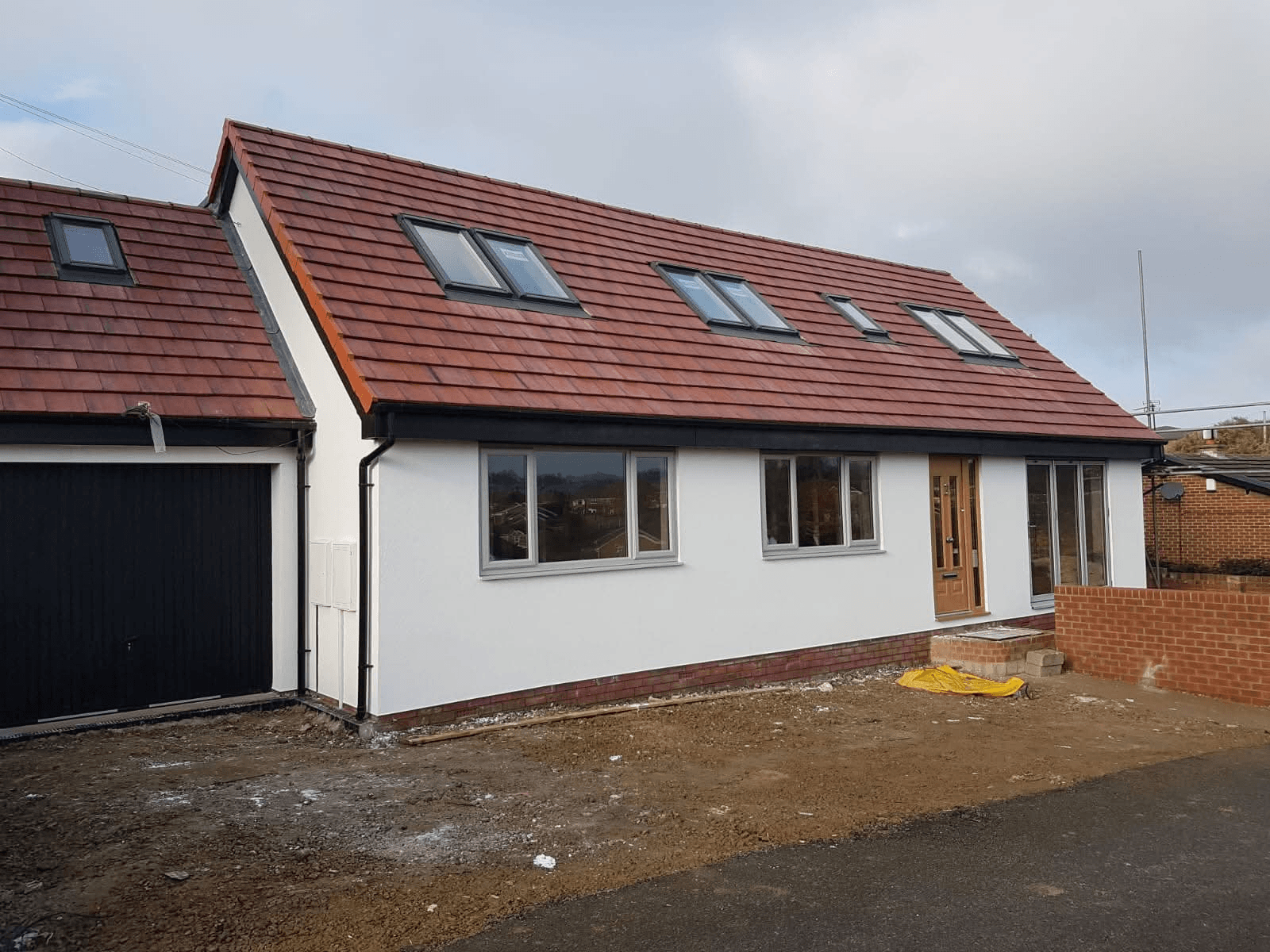White rendered bungalow with dormer and red roof tiles